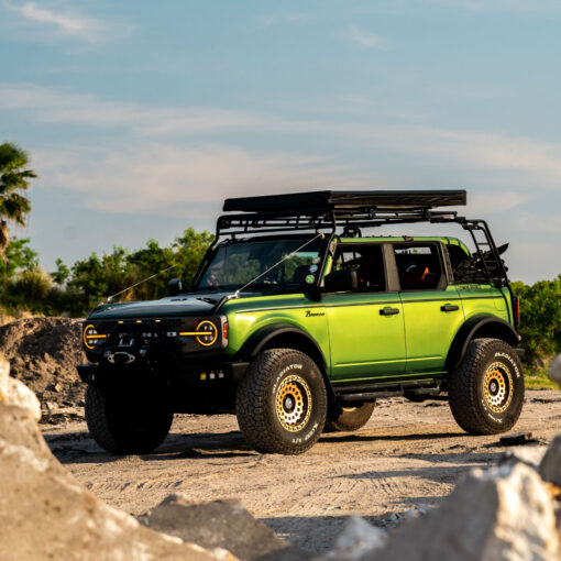 a green car parked on a dirt road