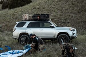 Two Men Setting Up a Tent in Front of Their Silver Toyota 4Runner with GOBI Racks Roof Rack
