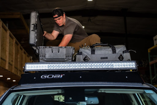 The Best Trucks with LED Lights for Off-Roading and Night Driving | GOBI Racks Man Loading Boxes onto a GOBI Racks Roof Rack Featuring a Light Bar