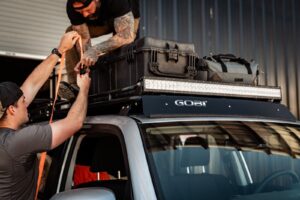 Two Men Securing Luggage to a GOBI Racks Roof Rack