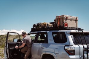 Man Getting Out of Silver Toyota 4Runner with a GOBI Racks Roof Rack on Top Carrying Supplies