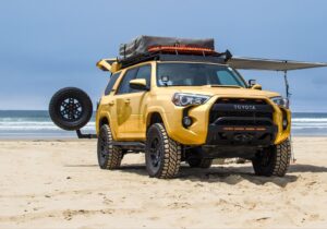 Yellow Toyota 4Runner TRD Pro with off-road tires, a GOBI Racks rack, and a rooftop tent