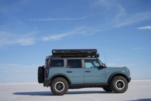 Blue Ford Bronco with a GOBI Racks Roof Rack Driving on Salt Flats
